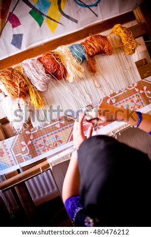 The woman  weaves carpet in the factory Royalty-Free Stock Photo #480476212