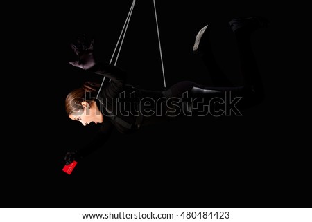 Beautiful woman hanging from wire cables stealing credit card, identity theft crime concept.