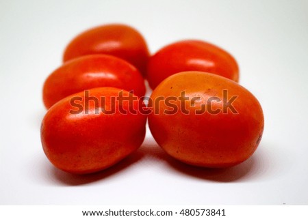 Red tomatoes on white background. Fresh red tomato closeup. Bunch of tomatoes closeup photo. Fresh vegetable tomato. Tomato soup cooking. Raw food for vegetarian. Tomato salad cook. Small oval tomato 