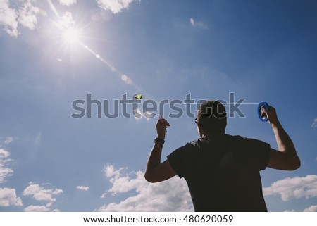 Silhouette of a young man flying a kite. 