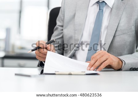 Senior analyst managing business accounts. Close up of a senior businessman hands checking final report before submission. Close up of hands of leadership signing business contract. Royalty-Free Stock Photo #480623536