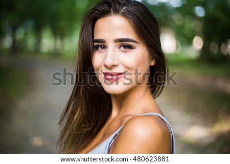 Outdoors portrait in park of a beautiful tanned teen student girl.