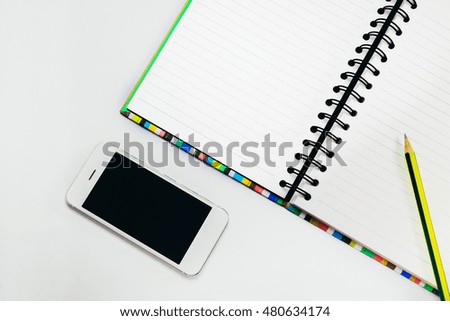 Blank screen Smartphone with notebook and pencil on white background