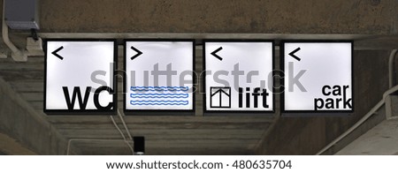 Under building sign for Toilet, wave, lift and car park