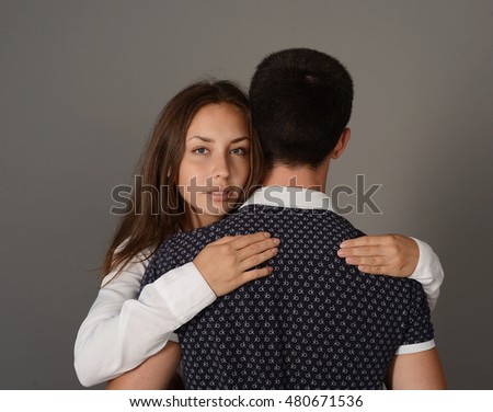 Happy young couple on a background of gray wall 