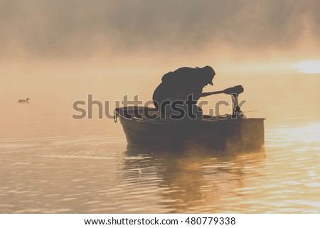 Unusual morning in sunlight a lake of Czorsztyn with floating angler. Picturesque photography filtered instagam style.