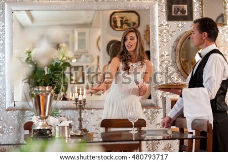 Young woman and butler in dining room