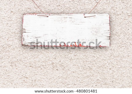 Wooden sign hanging on the white opaque concrete wall background and with copy space