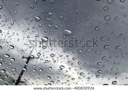 Rainy droplet on the window in cloudy weather
