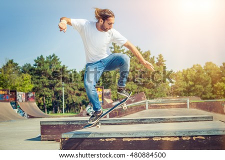 Action shot of a skateboarder skating at the skate park with concrete ramps