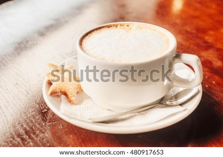 Cup of coffee on the table . white Cup next to spoon and cookies