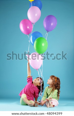 Happy children with colorful air ballons over blue