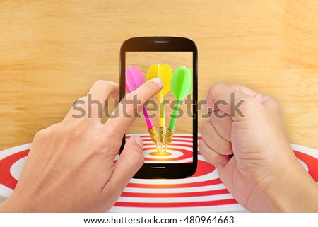 smartphone screen with arget dart with arrow over wooden background ,abstract background to target marketing concept .