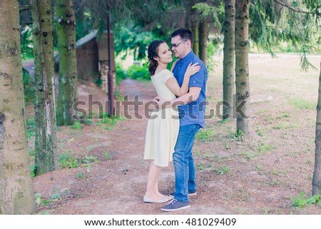 a beautiful young woman and her boyfriend couple are on the lake pond river and hugging, love story, after marriage, braided hair, bright images, tenderness. big bouquet of pink roses