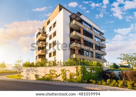 New modern block of flats in green area with blue sky Royalty-Free Stock Photo #481059994