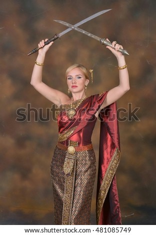 Blonde foreigner woman  in Thai traditional dress with swords