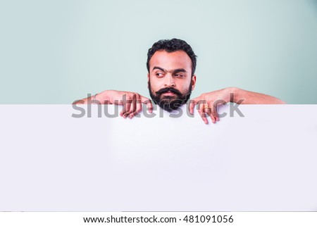 Hipster Indian/Asian young man with beard and moustache Displaying Blank Empty white Business Card