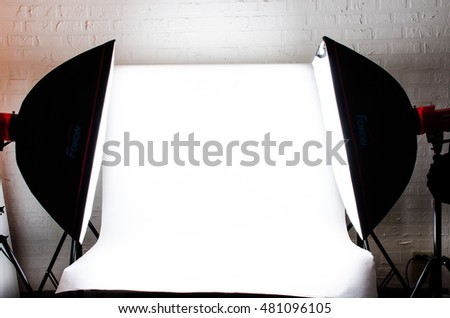 White backdrop with camera studio Flash in room white brick on wall