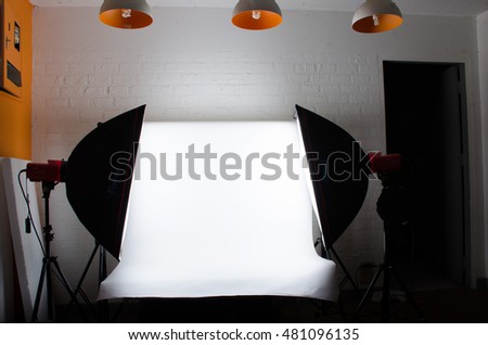 White backdrop with camera studio Flash in room white brick on wall