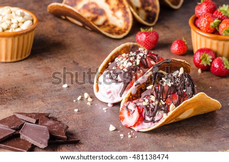 Homemade tacos with ice cream, nuts and chocolate, delicious strawberries