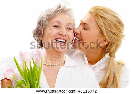 Portrait of pretty woman kissing and embracing her mother during holiday