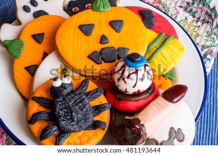 Above view of creative fondant cookies with halloween spider,witch finger,pumpkin and bloody eyes