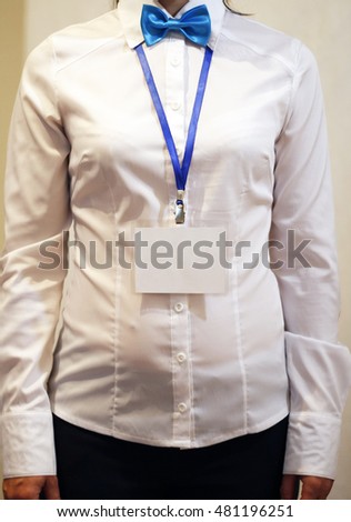 Woman wear blank white vertical badge mockup, stand isolated. Name tag on neck. Person identity label. Empty id card mock up. Representative. Bow tie businesswoman with badge in a hand. Business card.