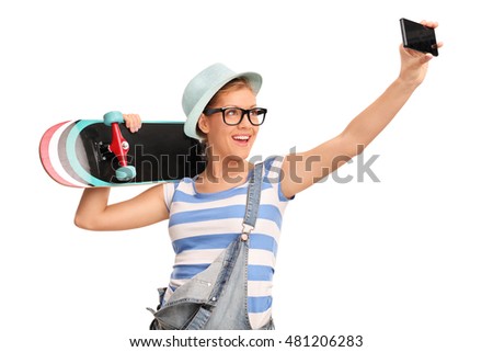 Female hipster taking a selfie and holding a skateboard isolated on white background