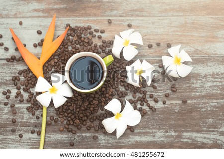 Green cup of coffee on vintage wood background and coffee bean; vintage style and tone
