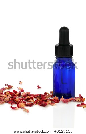 Aromatherapy essential oil glass bottle with dried   rose petals, isolated over white background.
