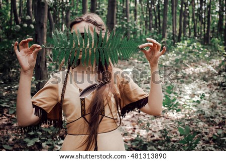 Native american beautiful girl with facepaint & spear in woods tracker healer