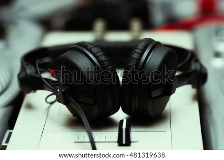 Dj headphones on sound mixer. Professional disc jockey headset and audio mixing controller on stage in night club. Play and listen to the music in hi fi quality