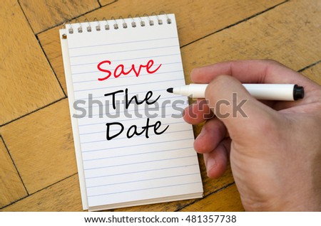 White notepad and human hand on the wooden background