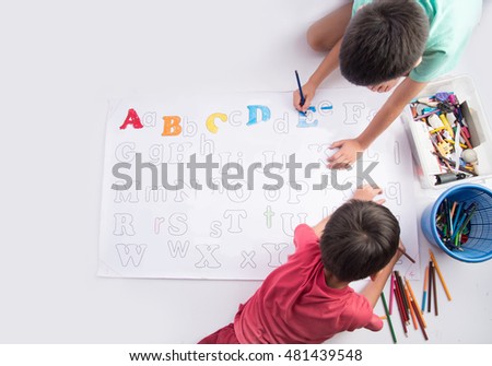 Little child boy painting and coloring alphabet  in the paper indoor activities