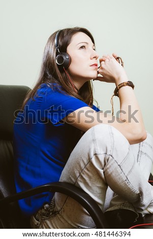 portrait of happy smiling pretty girl holding headphones listening music and looking up on olive copy space background