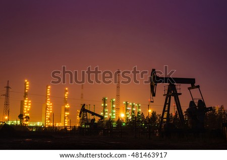 Oil rig at the background of refinery by night. Oil and gas industry. Toned.