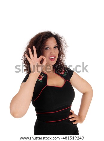 A happy young woman in a black dress signals with her hand it is perfect
in closeup, isolated for white background.
