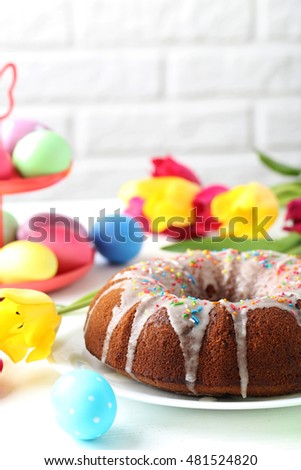 Easter eggs with cake on a white wooden table