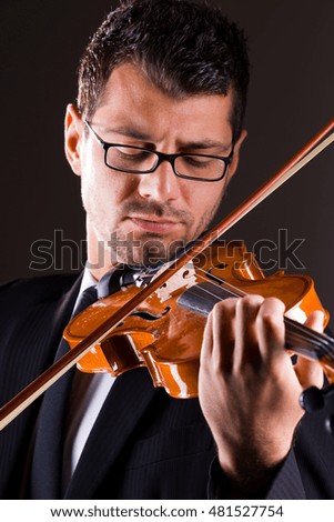 Violinist  playing violin on dark background,