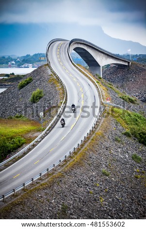 Two bikers on motorcycles. Atlantic Ocean Road or the Atlantic Road (Atlanterhavsveien) been awarded the title as "Norwegian Construction of the Century". Royalty-Free Stock Photo #481553602