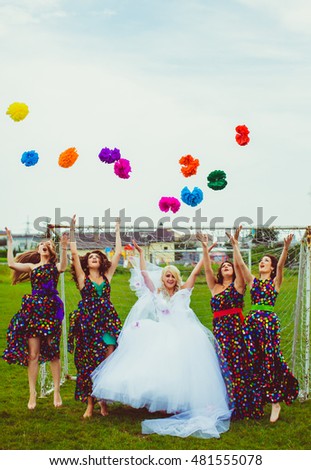 Bridesmaids and bride jump with the bright pompons before the goal