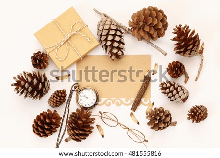 Top view of pine cones, gift box and blank card on white background