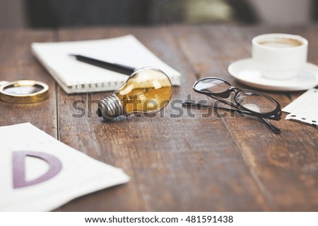 glowing bulb standing on the brown wooden background