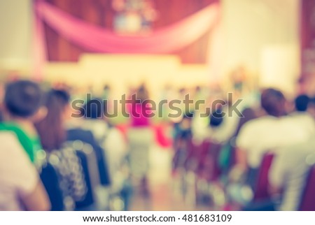 image of abstract blur people looking to kid 's show on stage at school  for background usage . (vintage tone)