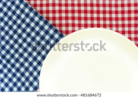 Top view plate on checkered tablecloth pattern background .Free space for products and for your text