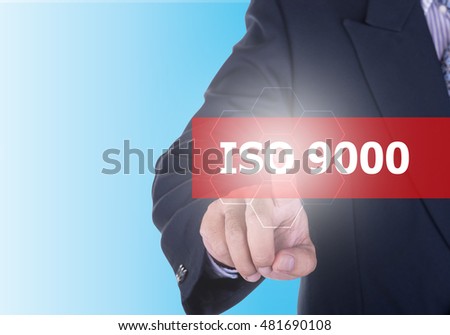 Businessman pressing iso 9000 button on virtual screens with word ISO 9000 blue background. Quality standart iso concept.