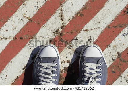 Background of old metal plate in red and white colors and blue sneakers