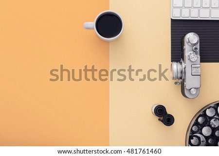 Work space on orange table of a creative designer or photographer with laptop, cameras other objects of inspiration and copy space. Stylish home studio concept of technology trends. View from above.