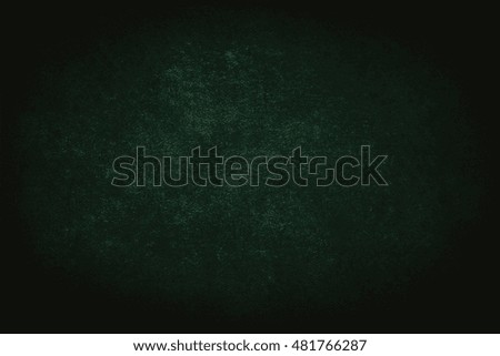 Green background or green Christmas paper with bright spotlight on black background texture for Christmas cards or background for St. Patrick's Day