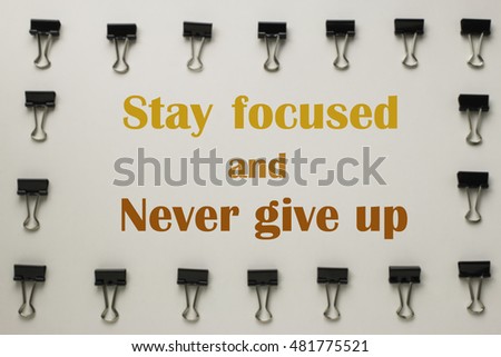 Inspirational quote "Stay focused and never give up" on blurred background